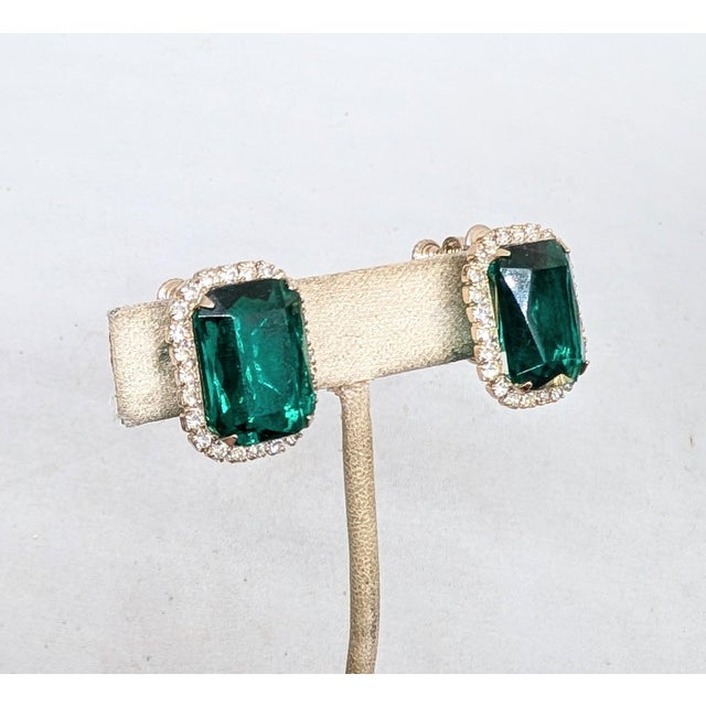 1960s rhodium plated emerald cut faux-emerald center with small round clear rhinestone surround clip and screw back...