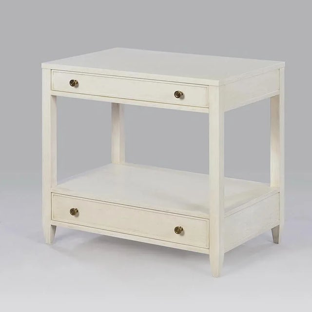 Classic Nightstand - A wide rectangle side table with two drawers, brass hardware, and tapered feet, has a “drift” white...