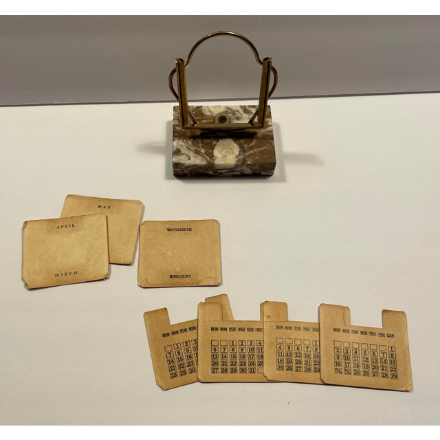 1950s MCM perpetual calendar with brass tone frame, marble base and 7 cards. There are three double sided month cards,...