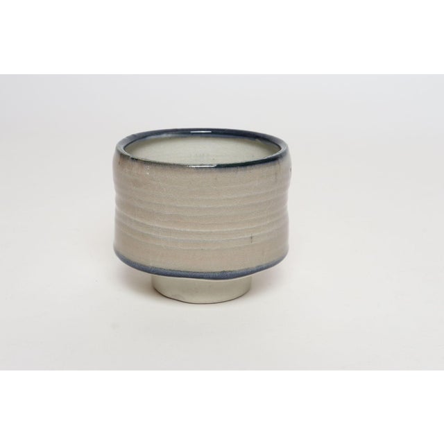 Diminutive stoneware footed vessel/bud vase by ceramicist, Deanna Nichols (b. 1942-2017, Missouri). Holding a BFA from...