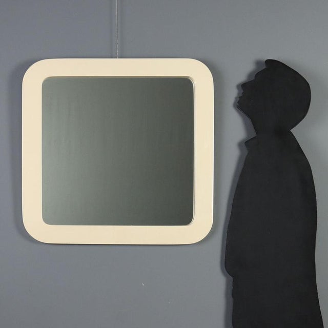 1970s wall mirror featuring a white plastic frame with rounded corners. This era-typical design combines functionality and...