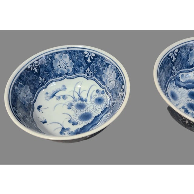 Discover the charm of traditional Japanese craftsmanship with this vintage pair of blue and white porcelain floral serving...