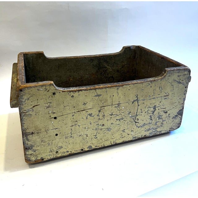 This is an open-top wooden storage box with distressed light green paint, exposing parts of the wood throughout.