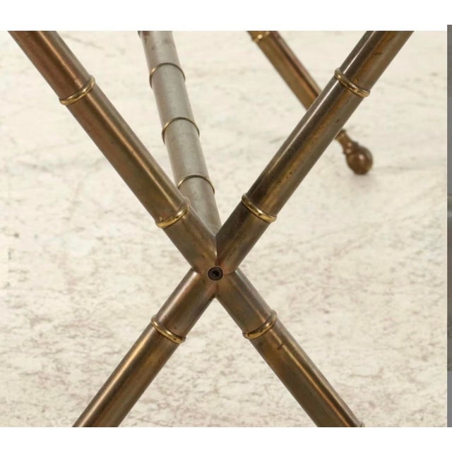 A striking vintage Hollywood Regency console table featuring a classic faux bamboo form in a warm, aged brass finish. The...