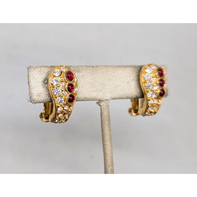 1960s goldtone with three cabochon faux-garnets down the center with round clear rhinestone surround clip earrings. Marked...