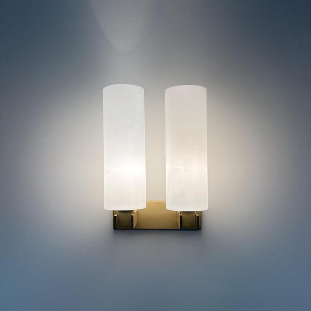 Rare Raak wall lamp model C-1515/2 made at Raak, Amsterdam, 1962. I quote, ‘An Opal glass cylinder, supported by the sleek...