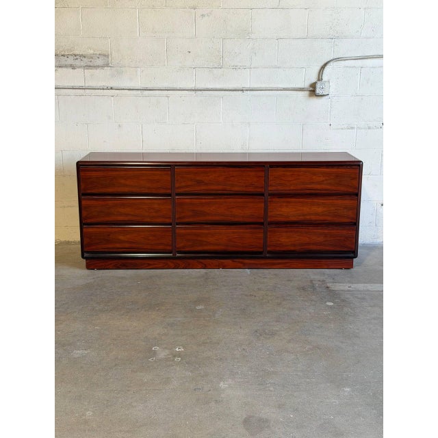 This exceptional lowboy silhouette features soft rounded corner edges and a seamless handleless front. Nine deep...