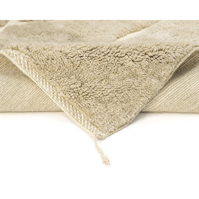 Sophisticated hand-knotted wool rug in dual shades of Taupe, with a striking Ivory flat-woven geometric pattern, combining...