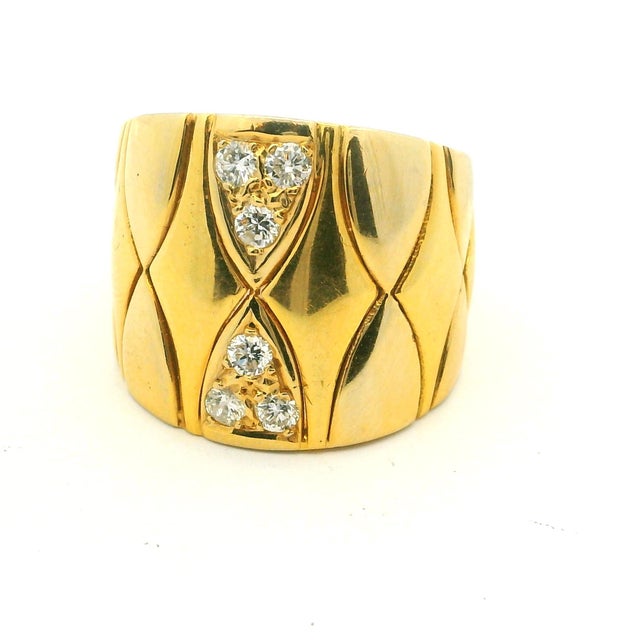 An Italian wide band ring from the 1980s, crafted in polished 18K yellow gold and set with six round brilliant-cut...