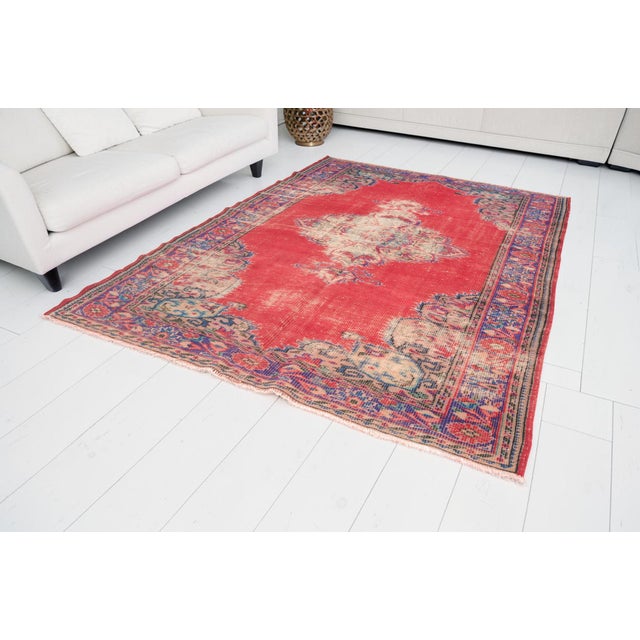 This is a vintage Turkish Oushak rug from the Mid 20th Century. The piece was hand-knotted.