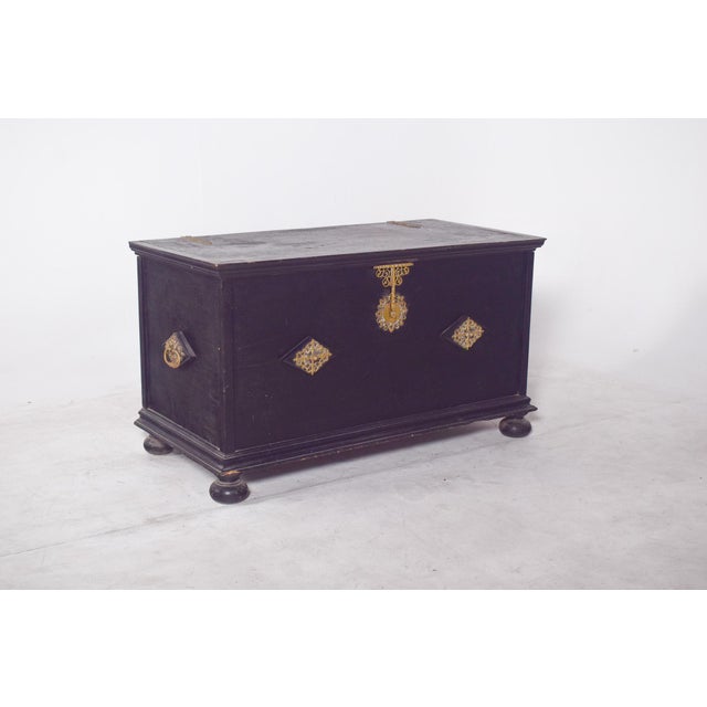 Chest with tray and gilded fittings. In very dark solid wood, with a cut-out base and wafer feet that give it firmness and...