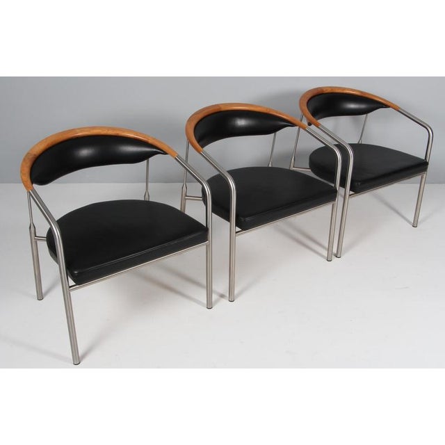 Henrik Tengler lounge chairs in steel and backrest of walnut. Upholstered with black leather. Made by Hansen & Sørensen....