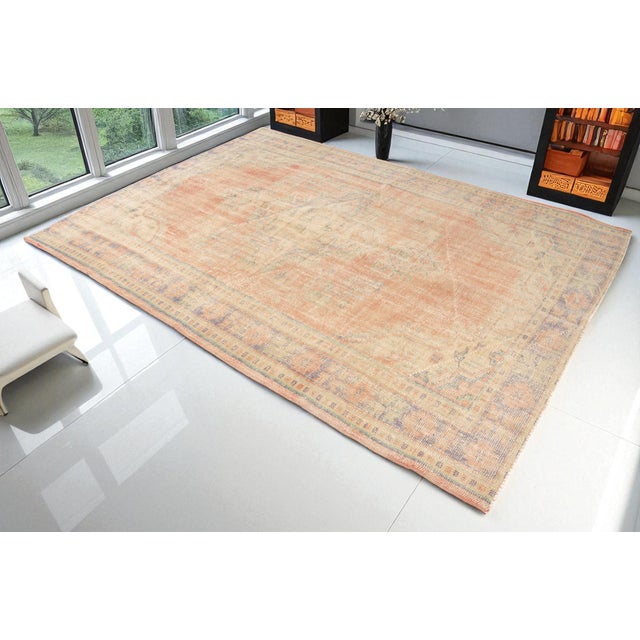 This is a vintage Turkish Oushak rug from the 1960s. The piece was hand-knotted.