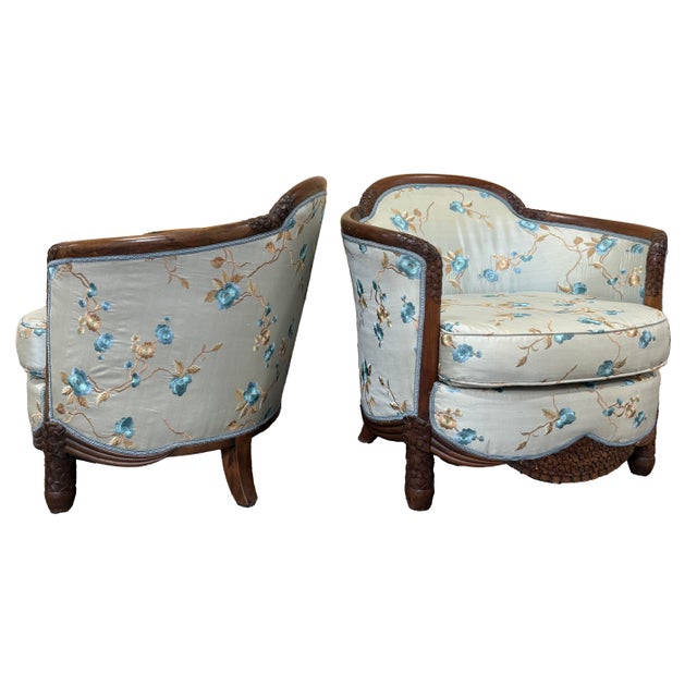 A pair of Chinese Export Art Deco armchairs, estimated circa 1920s–1940s, with a continuous hand-carved wood frame that...