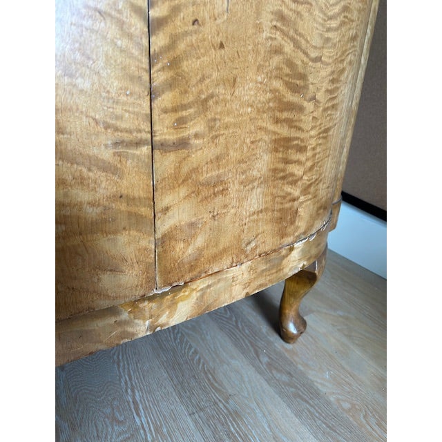 A striking Art Deco armoire featuring richly figured tiger maple veneer with dramatic book-matched grain patterns. The...