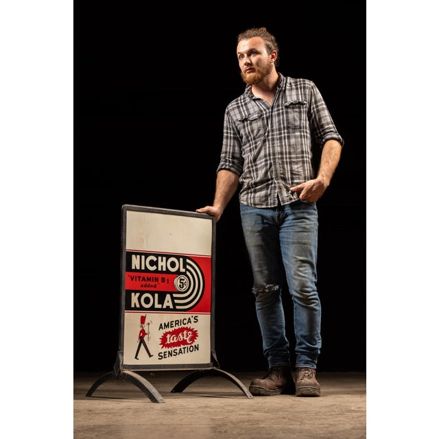 Vintage framed and mounted tin-lithographed advertising sign for Nichol Kola, a spicy-sweet cola introduced in 1936 by...
