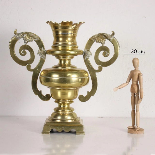 Solid brass gilt vase with large scroll loops. This piece is attributed to the mentioned designer/maker. It has no...