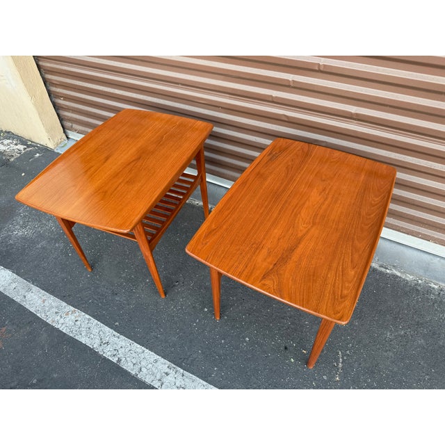 Beautiful matching pair of teak side tables from France and Son of Denmark. These tables were designed by the famed design...
