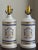 A lovely pair of mid-20th century porcelain armorial table lamps in the form of French apothecary jars. These gorgeous...
