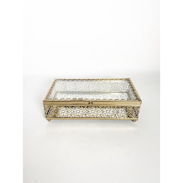 Decorative glass and metal jewelry box dating from the 2000s, France. The rectangular box features transparent glass...