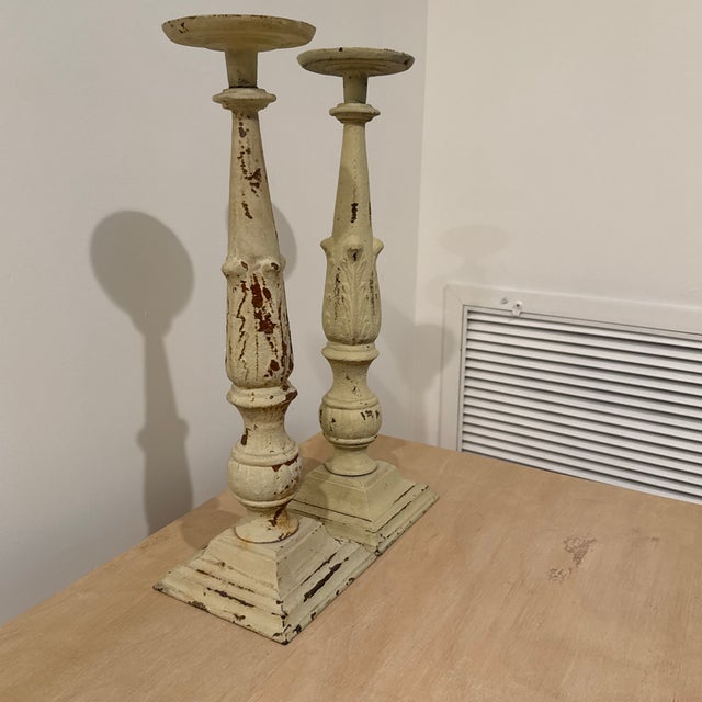 This is a pair of Vintage Neoclassical Cast Iron Pillar Candlestick Holders featuring a heavily distressed, chipped...