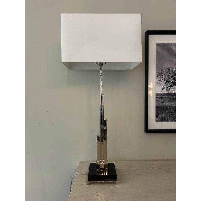 Skyscraper buffet lamp. Shown in polished nickel with a black stone base and white fabric shade. Curated by Arden Home....