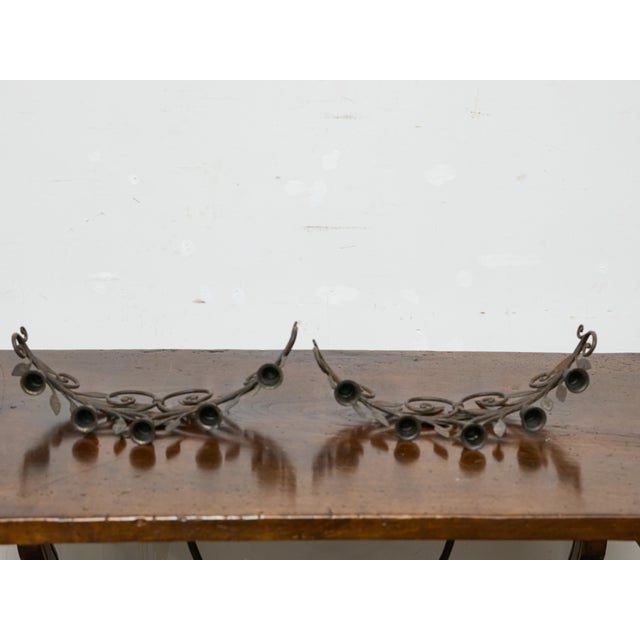 Crafted in France during the mid-20th century, this decorative pair of iron candleholders brings a sculptural, nature-...