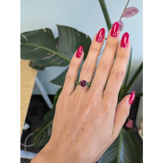 A 2.55-carat purple garnet glows in a rich grape-purple at the centre of this solid 14K white gold estate ring, surrounded...