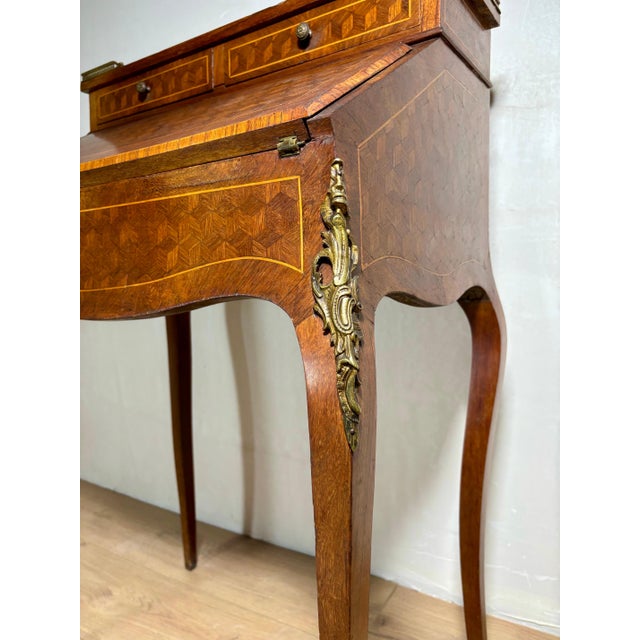 Elegant French secretary desk in Louis XV style, featuring a graceful slant-front form raised on slender cabriole legs....