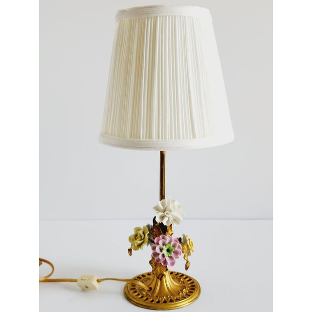 Lovely antique 18th Century French dresser or nightstand lamp, featuring an assortment of porcelain flowers and gilt metal...