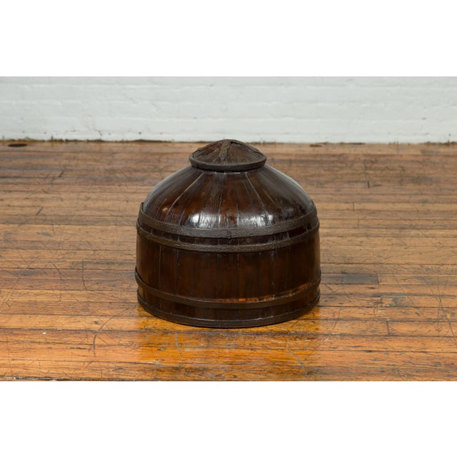 A Chinese antique decorative wooden cover from the 19th century. Charming us with its unusual shape and dark patina, this...