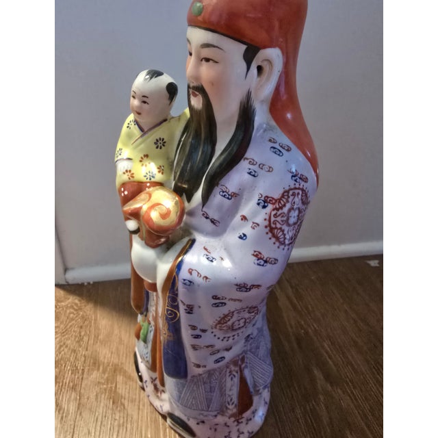 Hand-Painted Chinese Immortal Figurine with Child (Longevity Deity) Description: Striking hand-painted Chinese porcelain...