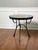 Italian Mediterranean hand-painted ceramic tile top table with a sculptural black iron base, circa 1950s. The top bursts...