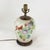 This antique table lamp is repurposed from an authentic white porcelain vase featuring a vibrant Famille Rose palette. The...