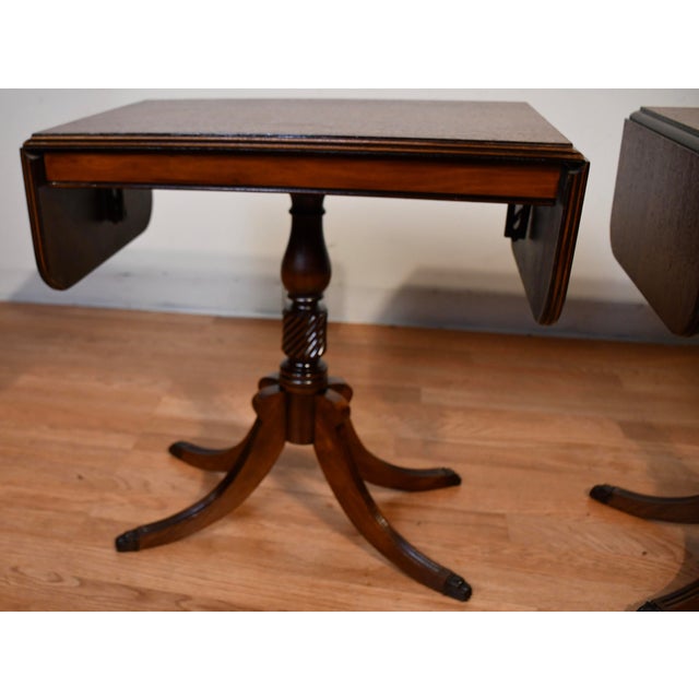 Description: Elegant pair of mid-20th century English Regency style Pembroke tables, crafted circa 1950 from rich,...