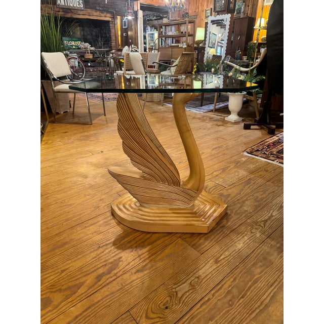Vintage Hollywood Regency style swan console or side table with glass top and a sculpted wood base, textured wings and an...