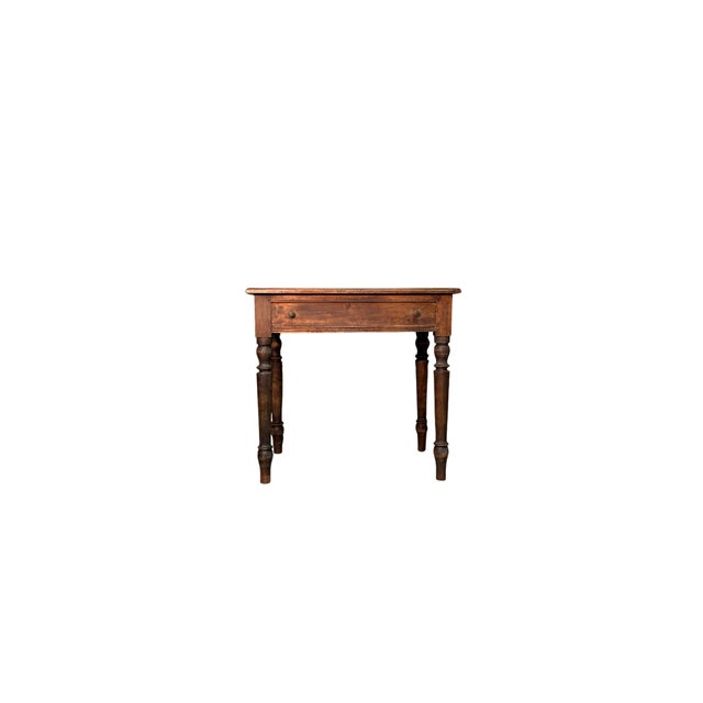 An elegant 19th-century walnut writing desk, featuring turned legs that lend a sleek, refined feel. Featuring a central...
