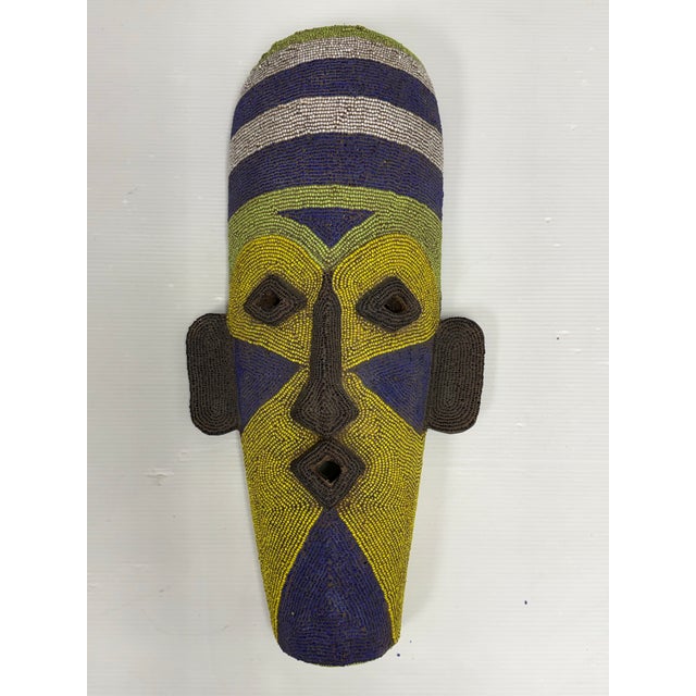 Design Plus Gallery presents a Handcrafted African Glass Beaded Carved Wood Mask. The carved wood form is adorned with...
