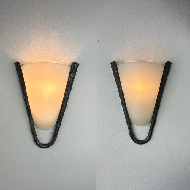 Vintage late 20th century wall sconces with frosted glass shades and hammered iron frames in a blackened finish. Clean,...