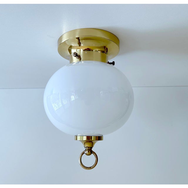 Vintage Limburg flush light, featuring globe glass shade mounted on a brass base with ring finial. Very good condition....