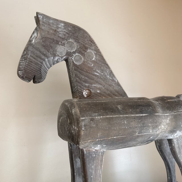 Rustic, primitive folk-art style carved wood horse sculpture featuring a weathered, distressed finish mounted on a black...