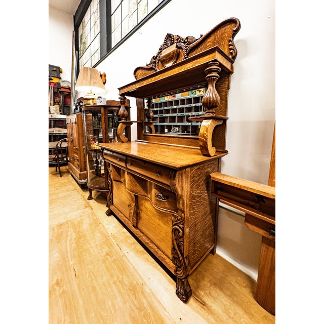 This Victorian-era tiger oak buffet is in wonderful condition, with a beveled mirror, ornate carvings, and claw feet. We...