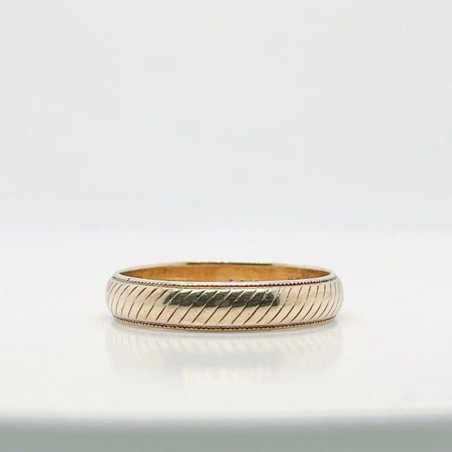 A very fine wedding band or ring. By Tiffany & Co. In 14k yellow gold. With engraved diagonal lines around the...