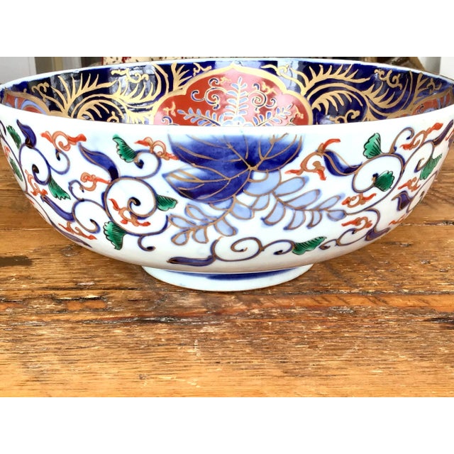 Large Japanese Imari Porcelain Bowl in blues, red, greens and a gold trim, featuring a botanical and geometric pattern....