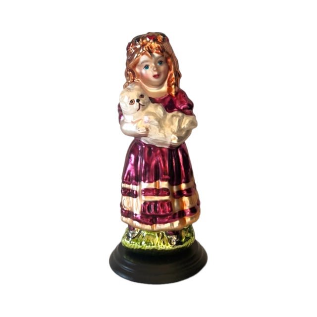A vintage Thomas Pacconi Classics blown-glass metallic Christmas figurine of a Victorian girls in a pink party dress...