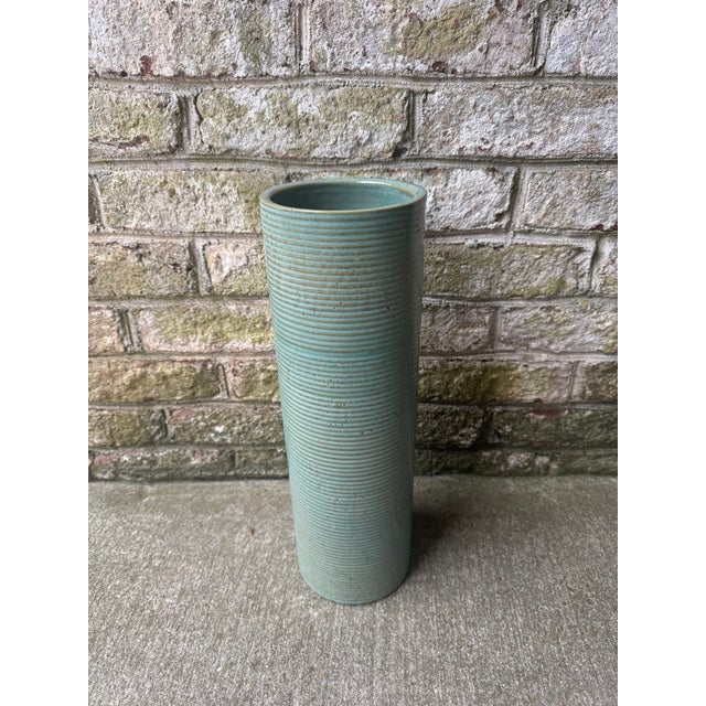 Turquoise blue ribbed ceramic pottery vase. This decorative vase is turquoise in color, with a tan color popping through...