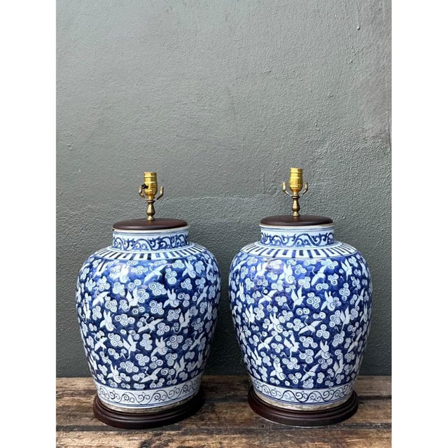 This vintage pair of monumental ceramic ginger jar table lamps brings timeless blue and white elegance to any room....
