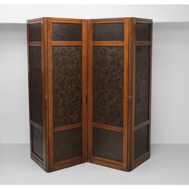 A superb and finely made Arts & Crafts movement four-fold double sided oak screen, with embossed paper inserts displaying...