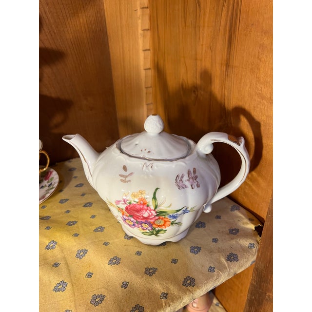 1950s, Mid 20th Century porcelain tea pot with hand-painted floral motifs and gold gilded accents. A wind-up music box...
