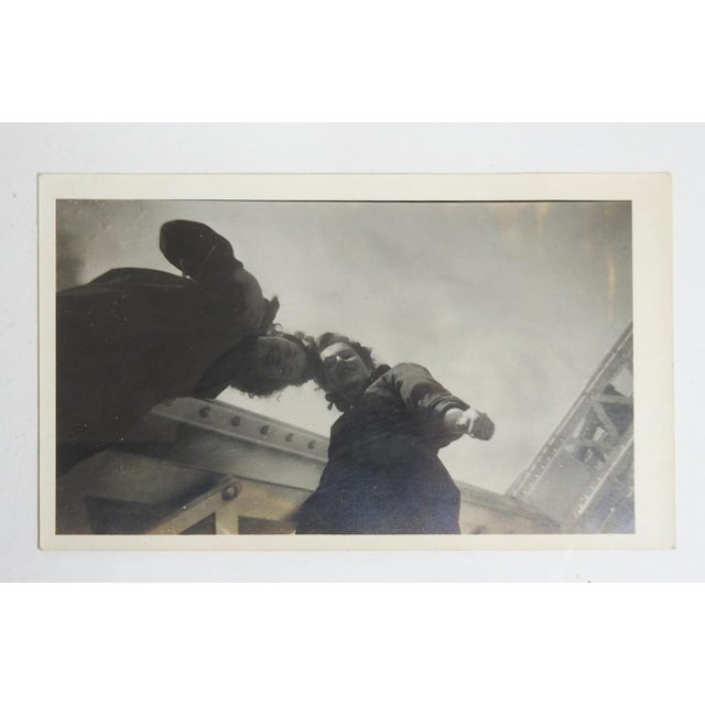 Mid 20th century snapshot photograph of two women being silly high on a bridge. Unframed.